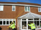 Cleaning windows above conservatories with the reach and wash system.
